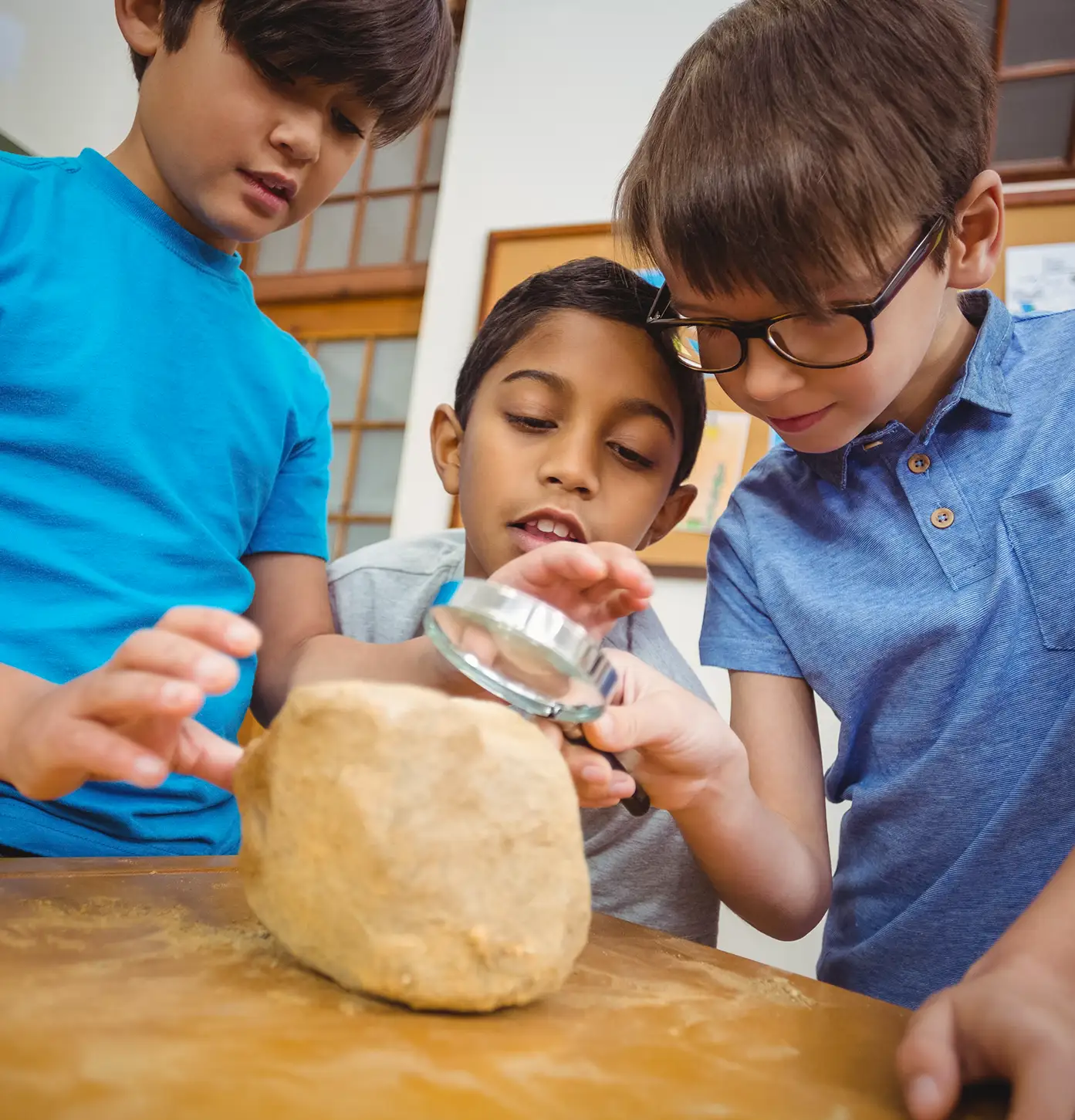 Students looking at a rock through magnifying glass